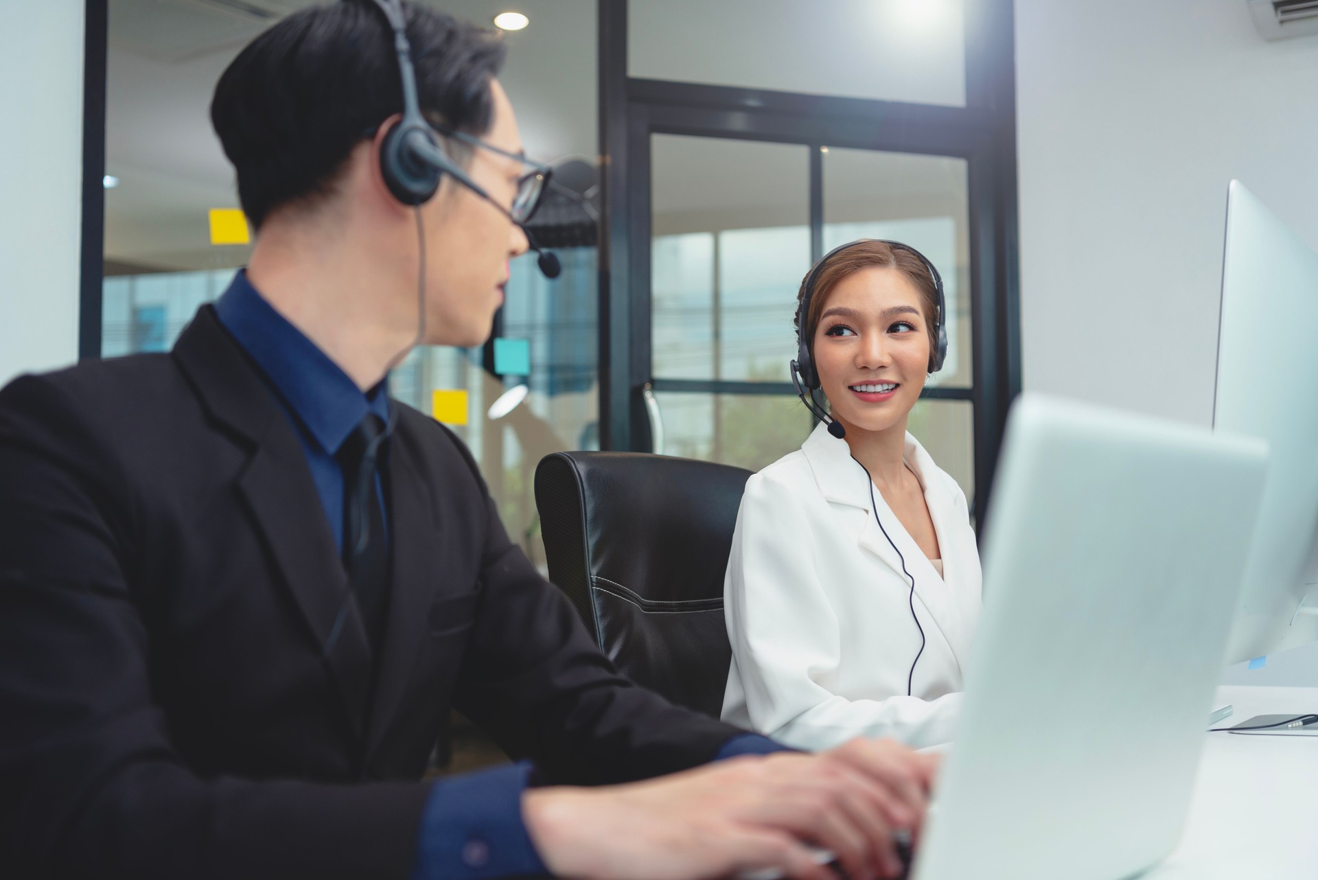 Equipe de agente de call center asiático, suporte ao atendimento ao cliente usando fone de ouvido ou fone de ouvido conversando com o cliente no escritório moderno.